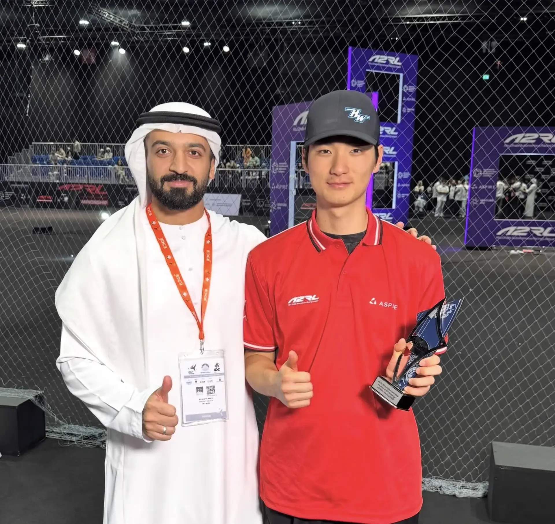 MinChan Kim holding the A2RL trophy alongside an official at the A2RL Drone Championship, Abu Dhabi, January 2026